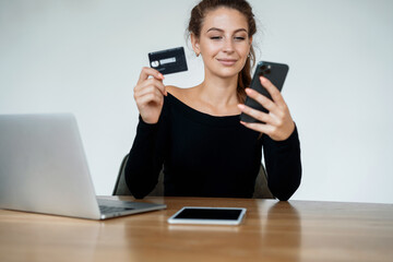 A woman makes purchases online. Ordering a shopping product on the store's website. An office employee works on a tablet in a coworking space. A blogger is surfing in a search engine on the Internet.