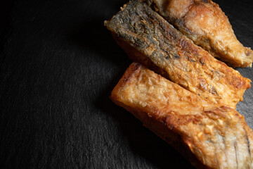 Three fried carp fish on a black background