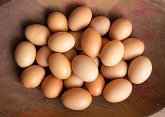 High angle view of a wooden bowl of chicken eggs in a farm.