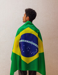 Back of a man with Brazilian flag hero cape. Flag and Independence Day Concept Image.