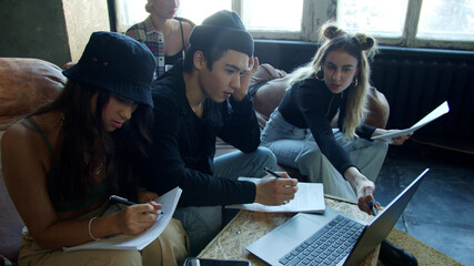 School friends studying lesson online and writing down the information