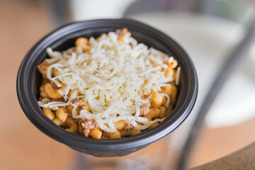Macaroni tv dinner with beef meat and gratted cheese on the top. Very shallow depth of field.