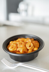 Tortellini pasta with rosa sauce and a plastic fork. Shallow depth of fields and copy space for your text.