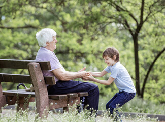 Mature man and his granson playing in summer park