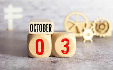 Cube shape calendar for October 03 on wooden surface with empty space for text.