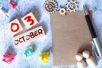 October 3. Date of October month. Number Cube with a flower and notebook on Diamond wood table for the background