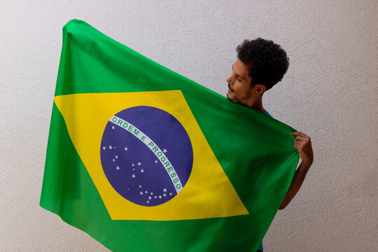 Black Man Holding a Brazil Flag Isolated On White. Flag and Independence Day Concept Image.