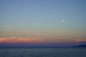 島に沈む夕日と月