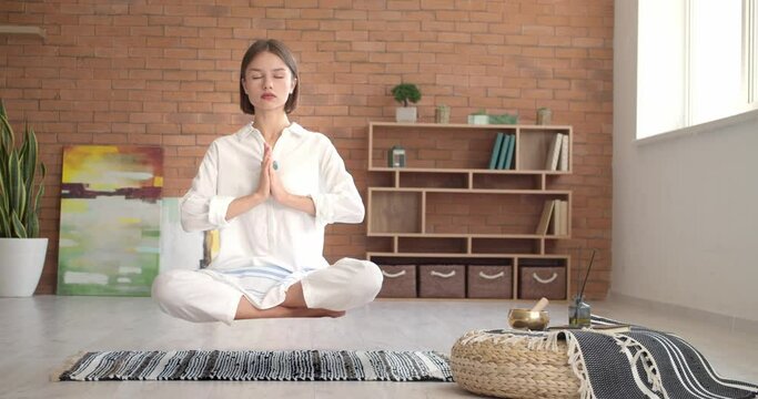 Levitating young woman practicing yoga at home