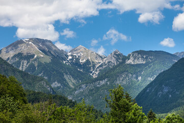 Fototapeta na wymiar Triglav, Mali Draski, Tosc and Skrlatica mounts in the Julian Alps, in Slovenia, by Bohinj, during a sunny afternoon in summer. Triglav vrh is the highest peak and mountain of Slovenia. ..