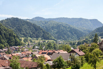 Fototapeta na wymiar Panorama of a suburban area of Slovenia, in Skofja Loka, a slovenian suburb of Ljubljana, with single family units and individual residential housing buildings and mountains in the background...