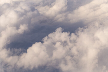 Stratosphere, a view of clouds from an airplane window.  Cumuliform cloudscape on sky. Flying over the land.