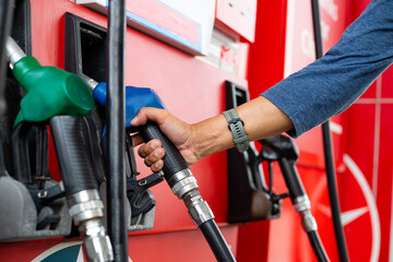 Holding nozzle petroleum for refill your fuel into engine care.Self service pump station