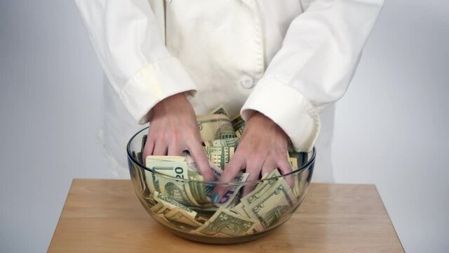 Mixed greens by hand mixing up paper money bills