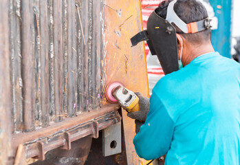 Worker cutting, grinding and polishing boiler machine.