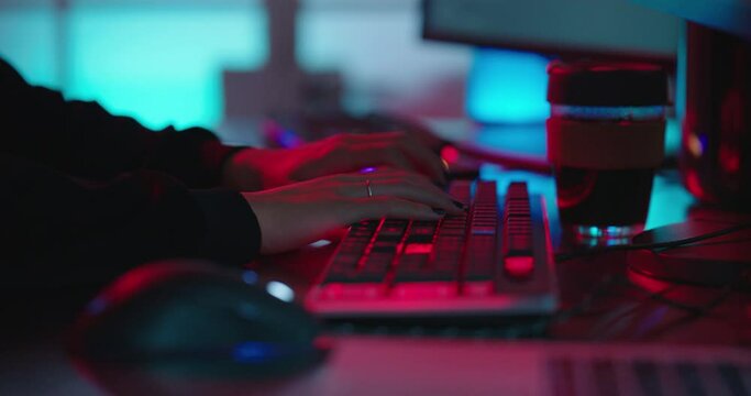 computer hands typing on keyboard programmer coding hacking data on internet cyber crime information hack by anonymous hacker using rgb gaming keyboard with blue backlight