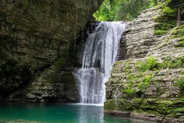 Fototapeta na wymiar The Olginsky Waterfall in the Republic of Abkhazia. Cloudy day on May 21, 2021