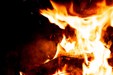 Close-up photo of a campfire. Flames on a black background. Cooking food over a fire.