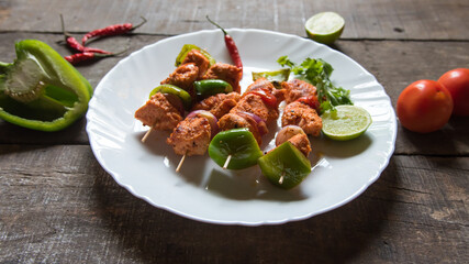 Chicken kebabs or doners grilled with saute vegetables in a white plate. Close up.