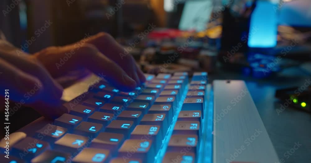 Wall mural computer hands typing on keyboard browsing online gaming late at night using keyboard with blue back
