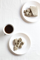 Cup of natural coffee.
Halva dessert in plates on a white background.
Copy of space, top view