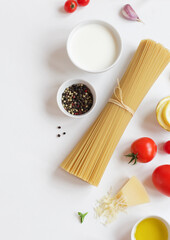 Ingredients for Italian pasta on a white background. Top view with copy space. Vegetarian food. Homemade food.