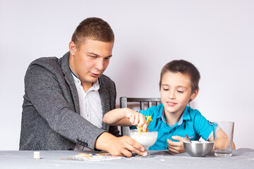 Chemistry education and training concept. Close-up of a boy and his dad making a home experience,...
