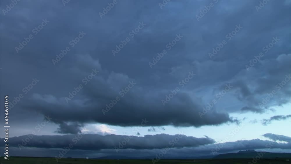 Poster time lapse of several layers of clouds moving towards camera in late afternoon