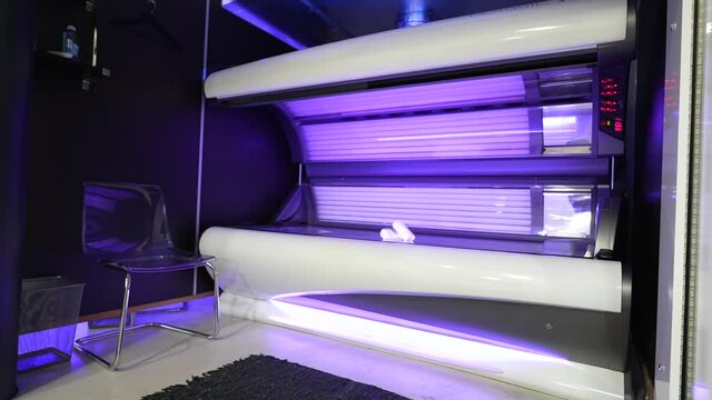solarium cabin with purple lights and towels on top.
