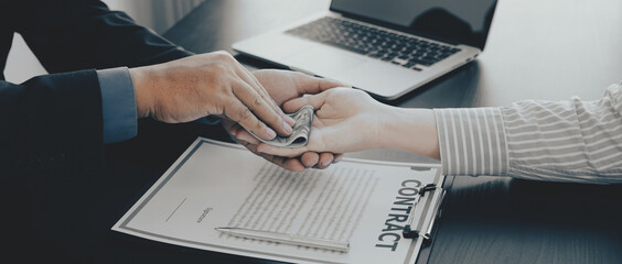 Businessman hand holding dollar bank note money to bribe financial officials or Boss is payout...
