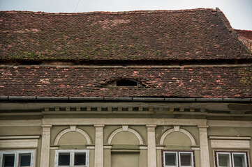 Stary dach z ozdobną fasadą i zniszczonymi dachówkami