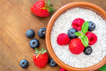 Chia seed pudding made with fruits and fresh  berries over wood background. Chia seeds Yogurt.