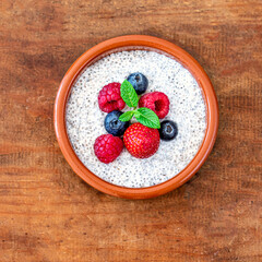Chia seed pudding made with fruits and fresh  berries over wood background. Chia seeds Yogurt.