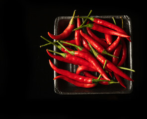 Chili red peppers in square black box on black background