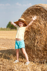 Little girl having fun in a wheat field on a summer day.