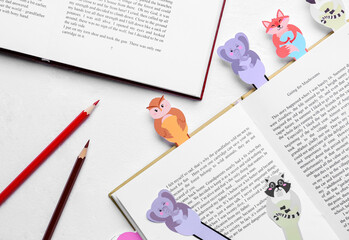 Cute bookmarks with books and pencils on white background