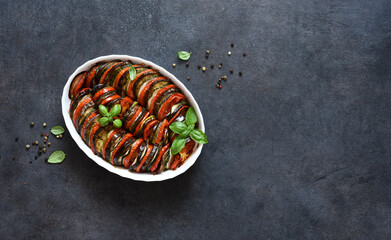 Vegetable ratatouille on a black concrete background, top view.
