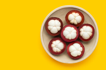 Mangosteen in plate on yellow background.