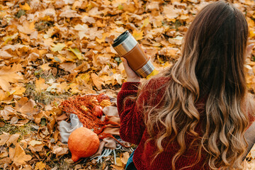 Zero Waste Fall Activities, Things to Do for Fall Season, Environmental friendly, eco living. Enjoying autumn season. Young beautiful woman with reusable coffee cup resting in fall autumn park.