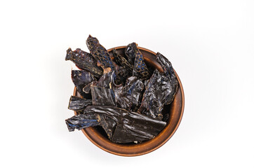 Dried dog treats in a brown clay bowl on a white background. Thin slices of dehydrated beef liver....