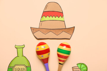 Mexican maracas, paper sombrero and tequila on color background