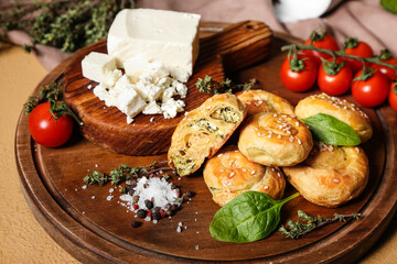 Puff pastry stuffed with spinach, feta cheese and vegetables on color background