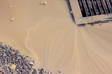 Brown water flows into the manhole