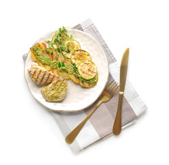 Grilled chicken meat and vegetables with pesto sauce on white background