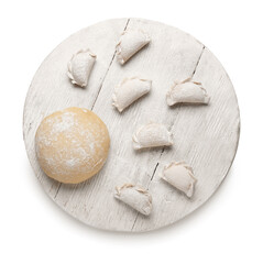 Wooden board with raw dumplings and fresh dough on white background