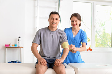 Fototapeta premium Physiotherapist working with patient in rehabilitation center