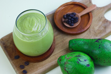 Avocado Coffee smoothie on clear glass on isolated background, with avocado fruits and coffee beans. 