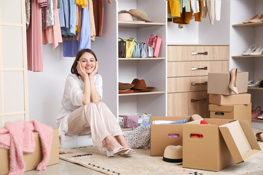 Young woman arranging clothes at wardrobe