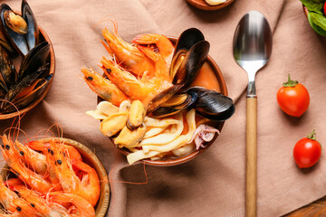 Bowl of tasty Cacciucco soup and ingredients on table