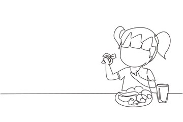 Single continuous line drawing girl eating fruit. Sitting near table eating orange. Watermelon and banana in tray placed on table at home. Healthy food for kids. One line draw graphic design vector